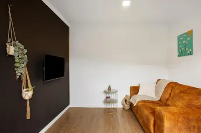 a living room with a brown leather couch at Green Shelter - Guest House in Santana