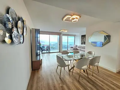 a dining room and living room with a glass table and chairs at Beautiful View by Rentallido in Funchal