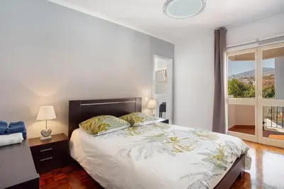 a bedroom with a bed and a large window at Funchal Centre Bliss -Soulful Stays in Funchal