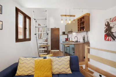 a living room with a blue couch and a kitchen at Seaside Haven - Soulful Stays in Porto Moniz