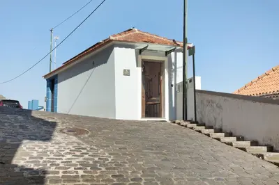 a small white building with a door on a street at Seaside Haven - Soulful Stays in Porto Moniz