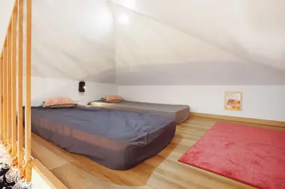 two beds in a room with a red rug at Seaside Haven - Soulful Stays in Porto Moniz
