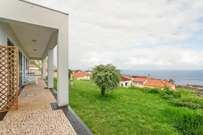 a white house with a view of the ocean at Blissful Haven - Soulful Stays in Porto Moniz