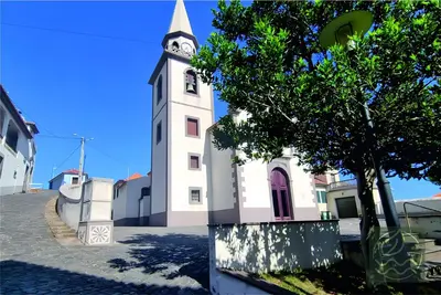 a church with a tower with a clock on it at Blissful Haven - Soulful Stays in Porto Moniz