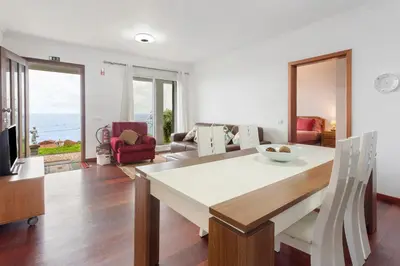 a kitchen and living room with a table and chairs at Blissful Haven - Soulful Stays in Porto Moniz