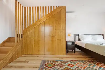 a bedroom with a bed and a wooden sliding door at Palheiro Simone by Homie in Lanceiros