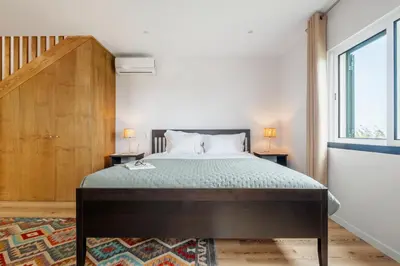 a bedroom with a bed and a large window at Palheiro Simone by Homie in Lanceiros