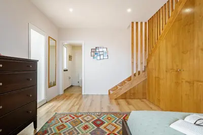 a room with a bed and a wooden stair case at Palheiro Simone by Homie in Lanceiros
