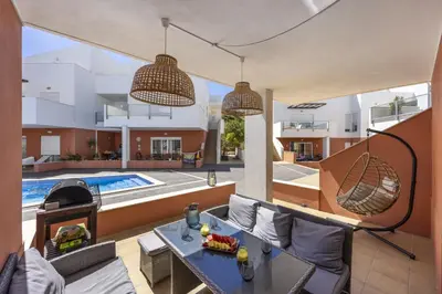 a patio with a table and chairs and a pool at Casa do Mar in Burgau