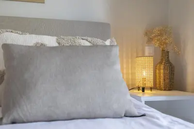 a bed with a pillow and a table with a lamp at Casa do Mar in Burgau