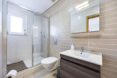 a bathroom with a toilet and a sink and a shower at Casa do Mar in Burgau