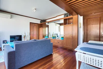 a living room with a blue couch and a kitchen at Top Floor Apartment 805 in Funchal