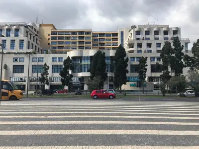 a parking lot with a red car in front of a building at Top Floor Apartment 805 in Funchal