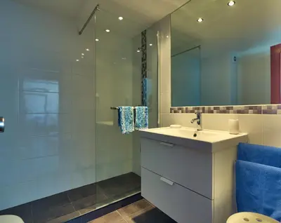 a bathroom with a sink and a shower with a mirror at Top Floor Apartment 805 in Funchal