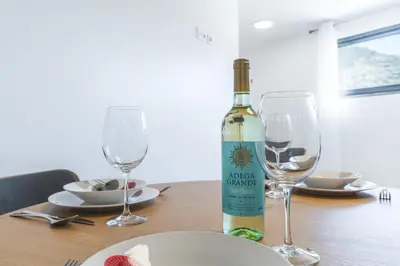 a bottle of wine sitting on a table with two glasses at Julianas House 2 by Atlantic Holiday in Campanário