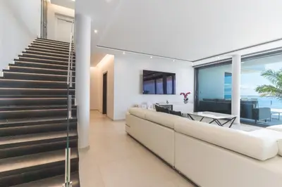 an open living room with stairs and a dining room at Villa Zenha by Atlantic Holiday in Ribeira Brava