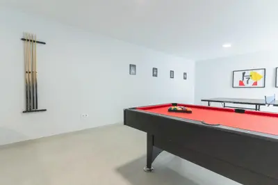 a ping pong table in an empty room with a pool table at Villa Zenha by Atlantic Holiday in Ribeira Brava