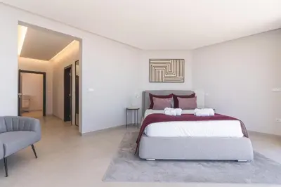 a bedroom with a large bed and a chair at Villa Zenha by Atlantic Holiday in Ribeira Brava