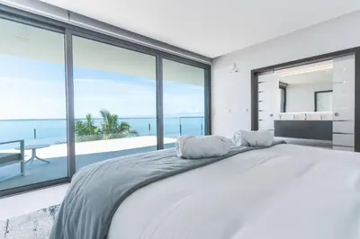 a bedroom with a large bed with a view of the ocean at Villa Zenha by Atlantic Holiday in Ribeira Brava