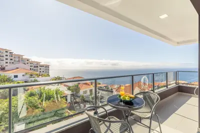a balcony with a table and chairs and the ocean at Garajau Sea Side by Atlantic Holiday in Caniço