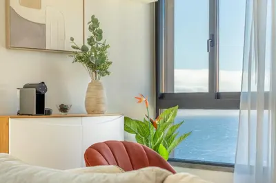 a living room with a chair and a window at Garajau Sea Side by Atlantic Holiday in Caniço