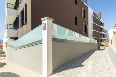 a building with a glass staircase on the side of it at Garajau Sea Side by Atlantic Holiday in Caniço