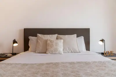 a bedroom with a white bed with two lamps at MarAnteMar by An Island Apart in Porto Santo