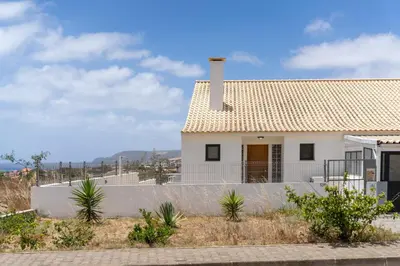 a white house with a chimney and a fence at MarAnteMar by An Island Apart in Porto Santo