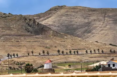 a hill with a white barn and a mountain at MarAnteMar by An Island Apart in Porto Santo