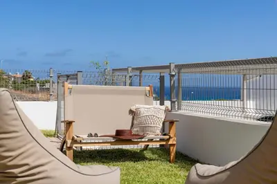 a hammock and a chair on a balcony at MarAnteMar by An Island Apart in Porto Santo