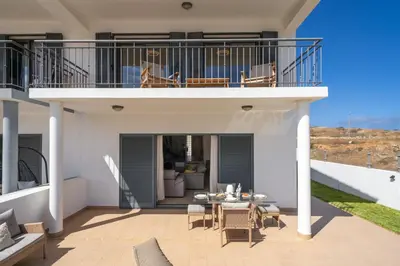 a house with a balcony with a table and chairs at MarAnteMar by An Island Apart in Porto Santo