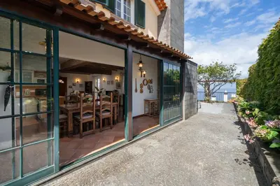 a house with glass doors and a patio with a table at Casa da Avo in Faial