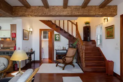 a living room with a staircase and a chair at Casa da Avo in Faial