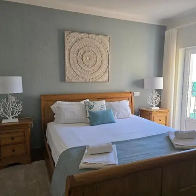 a bedroom with a large white bed with two night stands at Casa Azul in Luz