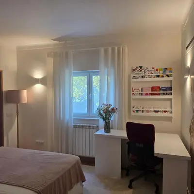 a bedroom with a desk and a bed and a window at Casa Azul in Luz