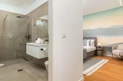 a bathroom with a shower and a toilet and a bed at Elysium São Vicente - Designer Villa with Ocean View, Heated Pool, Jacuzzi & Sauna in São Vicente