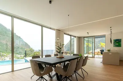 a dining room with a table and chairs at Elysium São Vicente - Designer Villa with Ocean View, Heated Pool, Jacuzzi & Sauna in São Vicente
