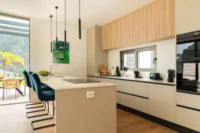 a kitchen with white cabinets and a counter top at Elysium São Vicente - Designer Villa with Ocean View, Heated Pool, Jacuzzi & Sauna in São Vicente