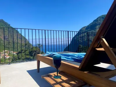 a balcony with a bed with a view of the mountains at Elysium São Vicente - Designer Villa with Ocean View, Heated Pool, Jacuzzi & Sauna in São Vicente