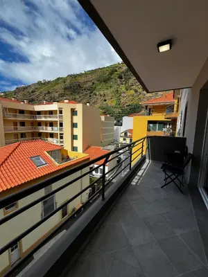 a balcony with a view of buildings and a mountain at Island Heart- Family Retreat- Free parking garage in Ribeira Brava