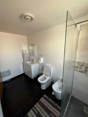a bathroom with a toilet and a glass shower at Island Heart- Family Retreat- Free parking garage in Ribeira Brava