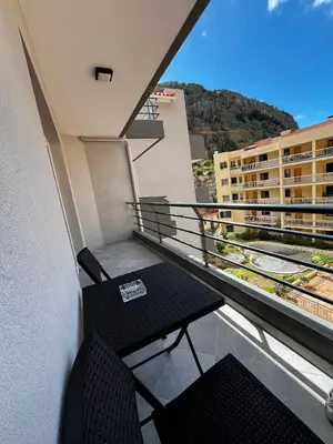 a balcony with a table and chairs on a building at Island Heart- Family Retreat- Free parking garage in Ribeira Brava