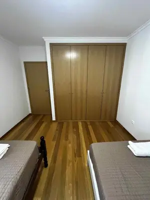 an empty bedroom with two beds and a wooden floor at Island Heart- Family Retreat- Free parking garage in Ribeira Brava