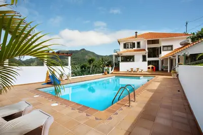 a swimming pool in the backyard of a house at Traveller's House in Machico