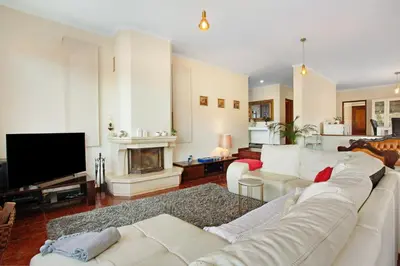 a living room with a white couch and a tv at Traveller's House in Machico