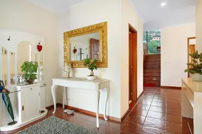 a bathroom with a white sink and a mirror at Traveller's House in Machico