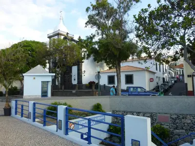 a blue fence in front of a white church at Shearwaternest Apartment AL in Funchal