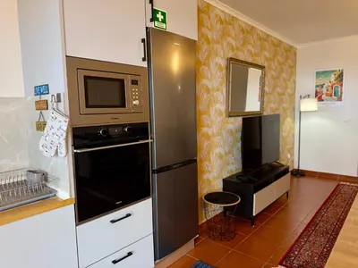 a kitchen with a refrigerator and a microwave at Airport Oasis in Santa Cruz