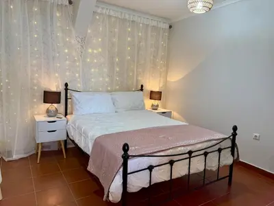 a bedroom with a bed and a window with lights at Airport Oasis in Santa Cruz