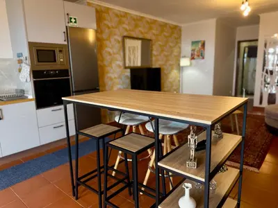 a kitchen with a table and stools in a room at Airport Oasis in Santa Cruz